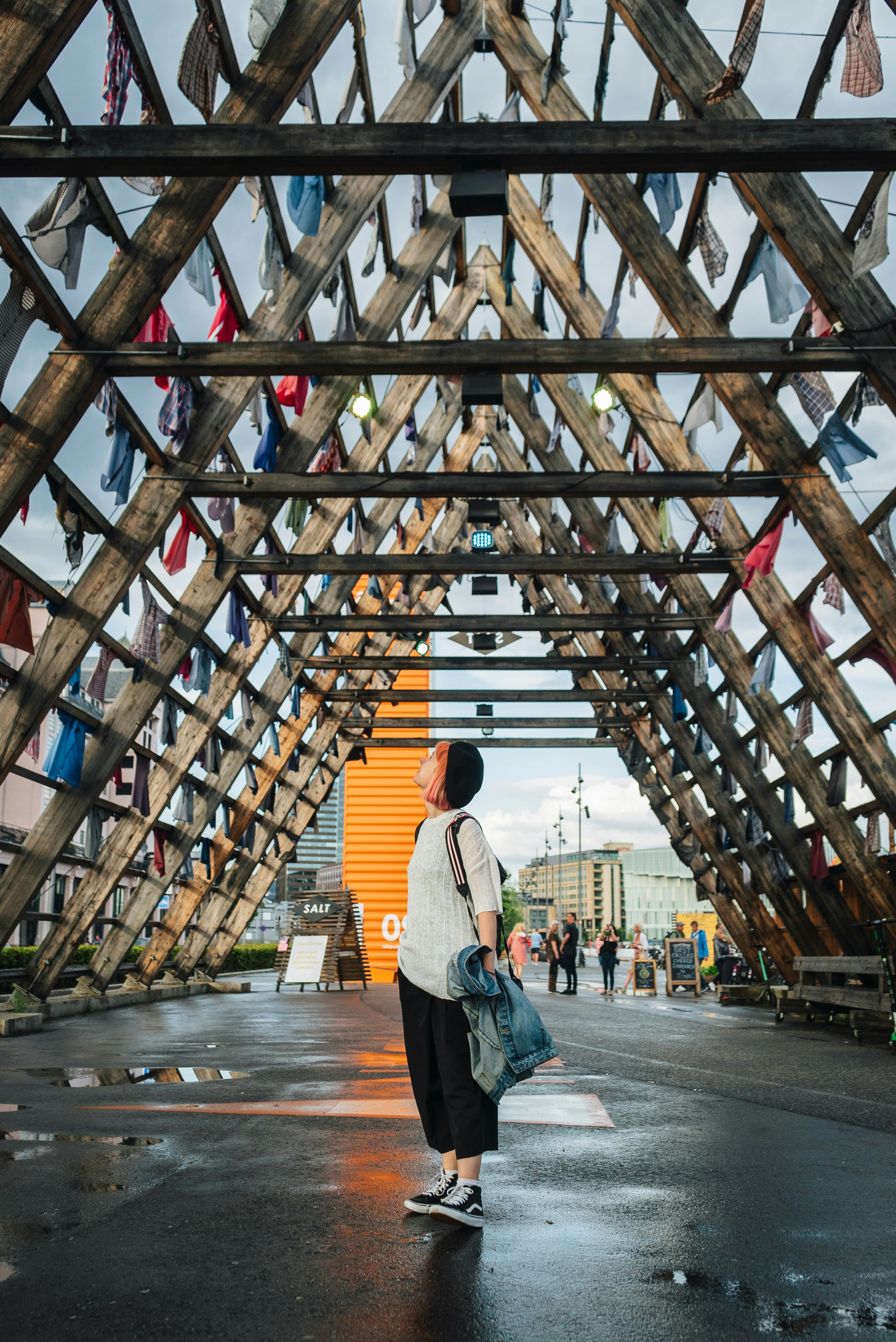 Girl under dry fishing  racks in Oslo, Norway by Nick Night